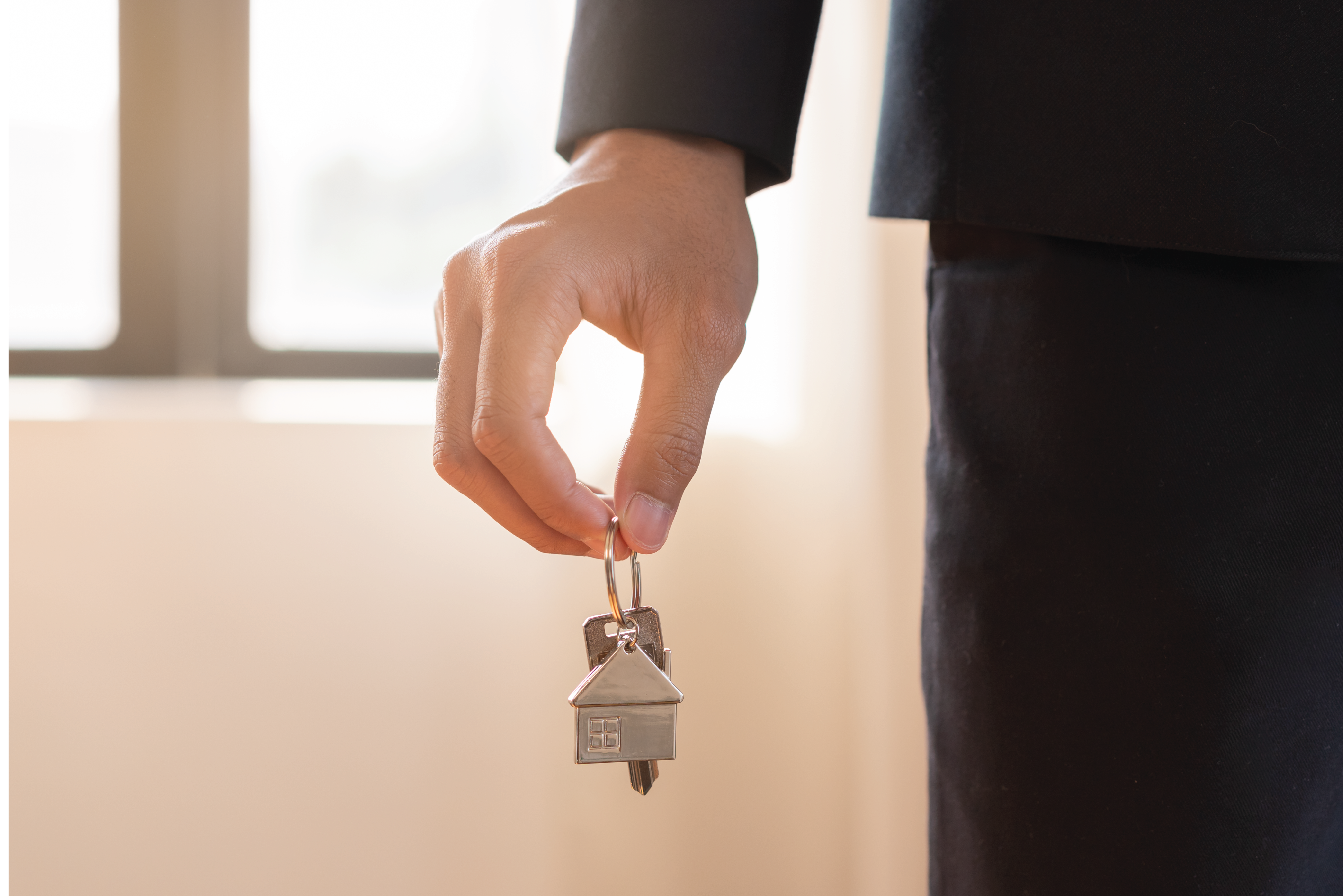 Image of hand holding a keyring with a house key
