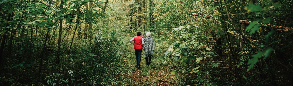 Two women walking in a forest. 