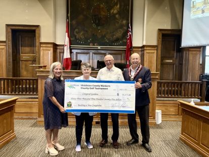 Image of Warden Brian Ropp presenting the Craigwiel Gardens staff with a cheque inside Council Chambers