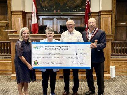 Image of Warden Brian Ropp presenting an oversized cheque to three representatives from Craigwiel Gardens