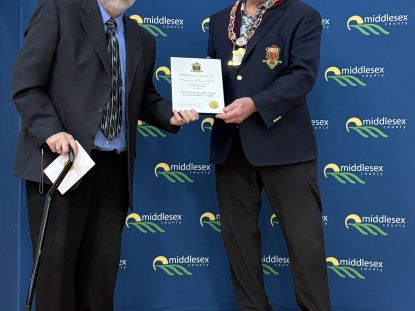 Image of Mark Isaac accepting award from Warden Brian Ropp